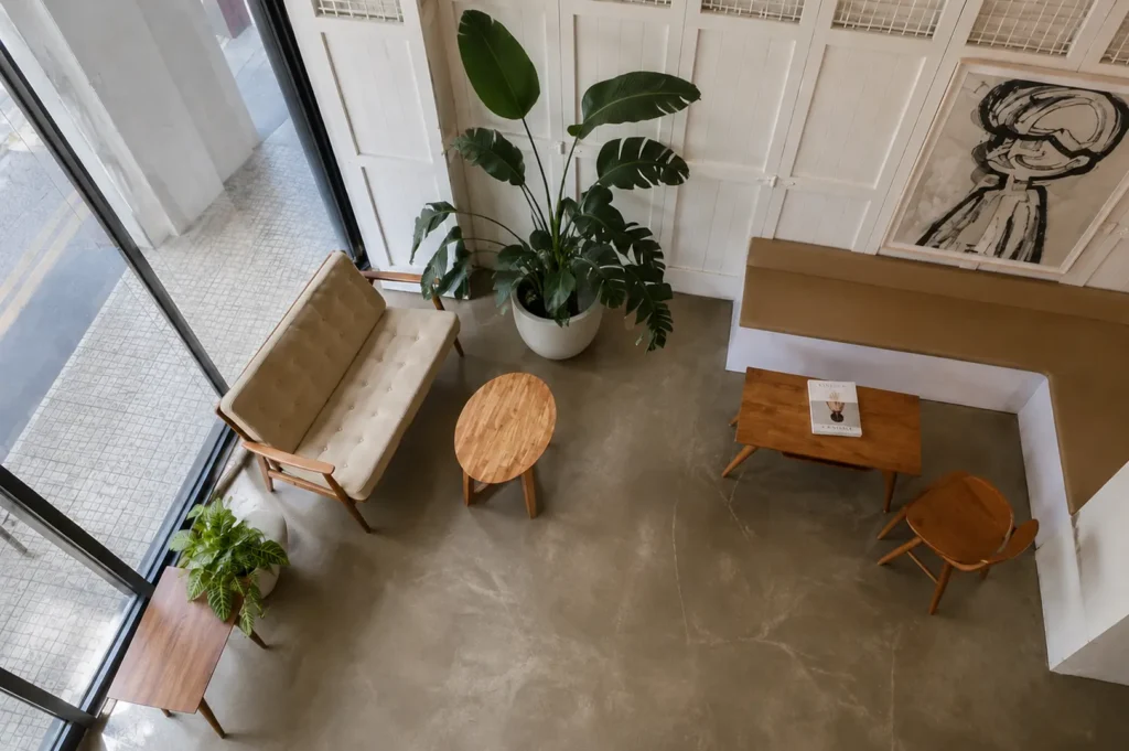Minimalist cafe interior with wooden furniture, plants, and white walls at Apartment Coffee