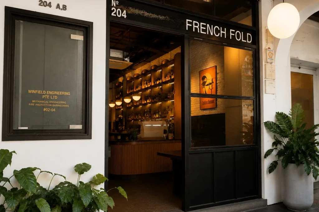 French Fold restaurant entrance with black storefront and warmly lit interior