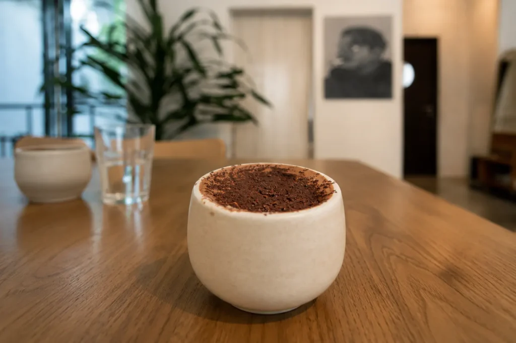 Hot chocolate with chocolate shavings in a ceramic cup on wooden table