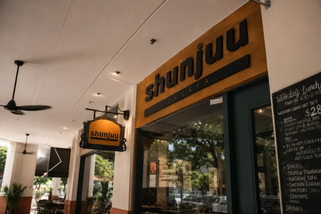Wooden exterior signage and hanging sign for Shunjuu Izakaya restaurant