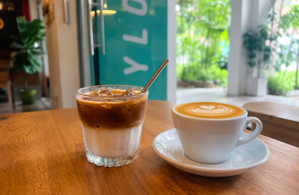 Iced coffee and hot latte served on a wooden table