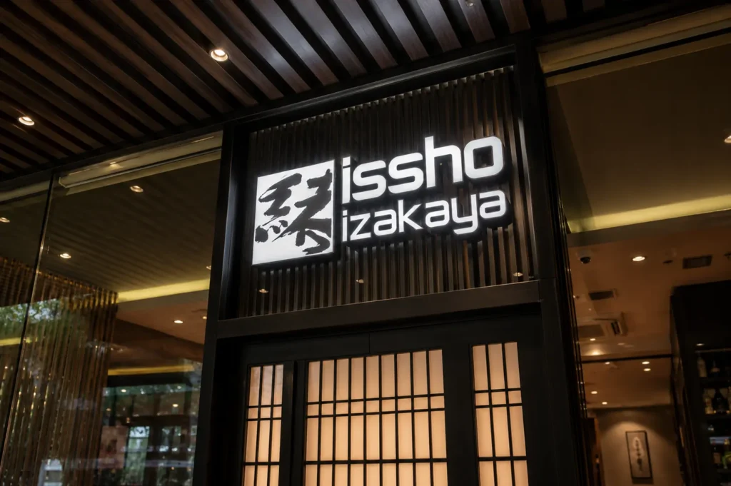 Illuminated Issho Izakaya entrance sign with dark wooden slats and shoji doors