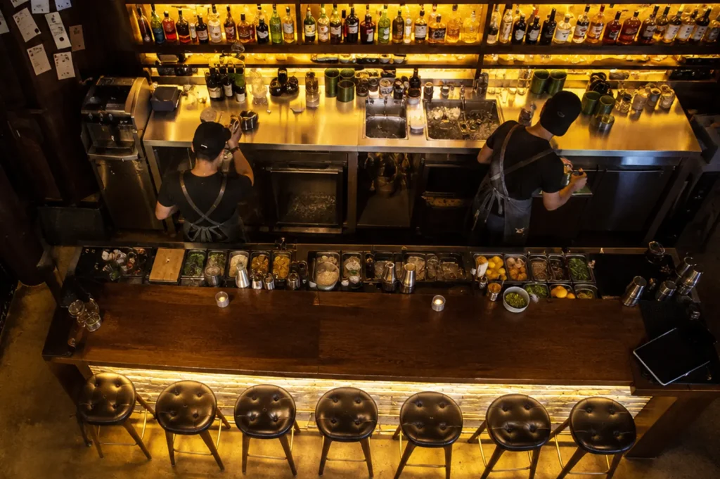 Overhead view of Neon Pigeon bar with bartenders preparing drinks