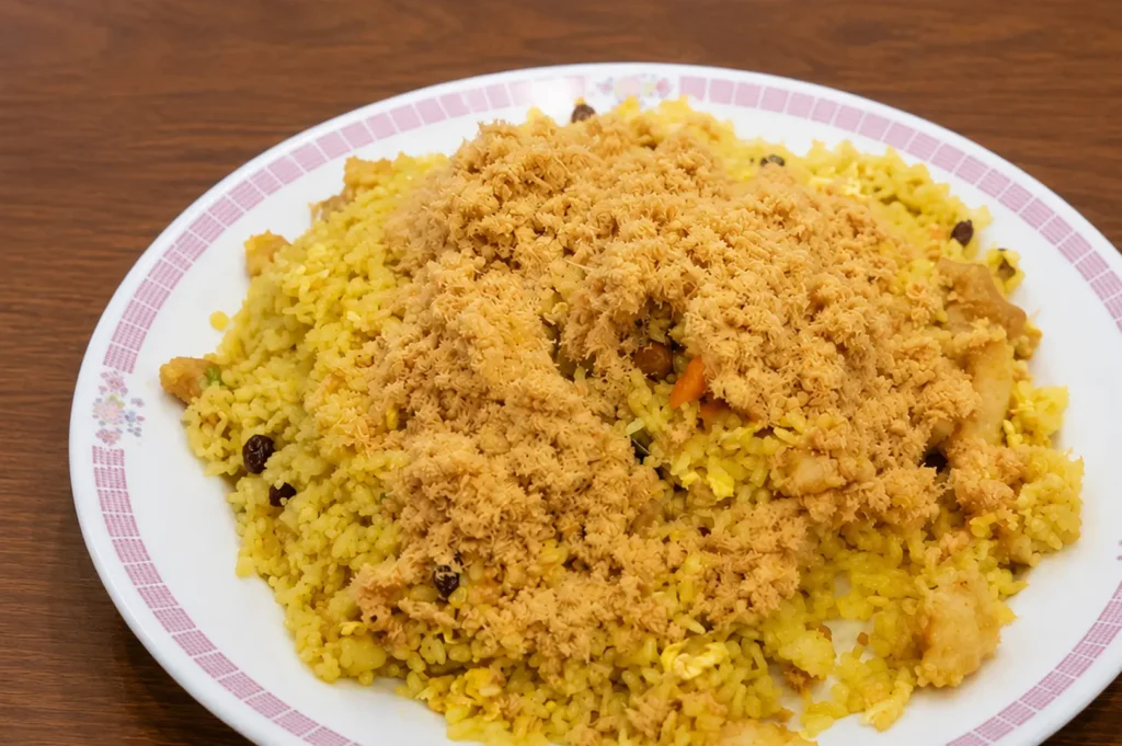Pineapple fried rice topped with crispy pork floss on decorative plate