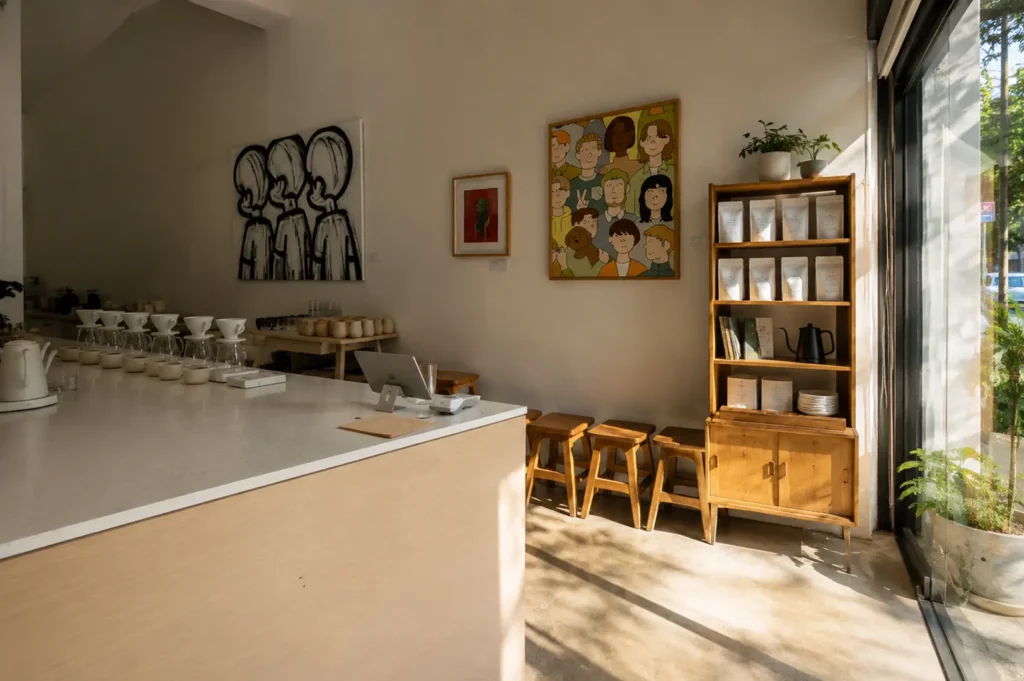 Bright and minimalist interior of Apartment Coffee cafe with wooden furniture and artwork