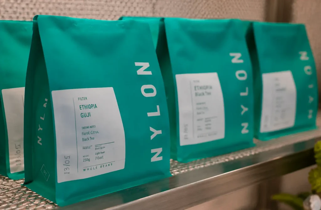 Packaged coffee beans displayed on a shelf in teal bags