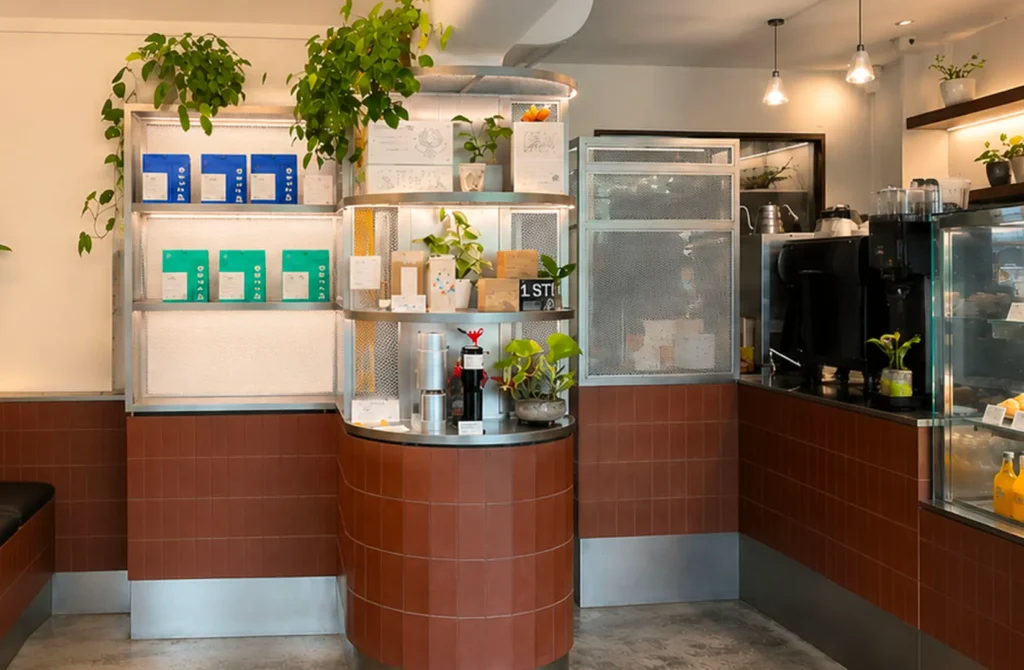Bright modern coffee shop interior with plants and product shelves