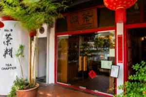 Tea Chapter storefront at No. 9 Neil Road featuring red and white facade, traditional Chinese signage, bamboo plants, and hanging red lanterns in Chinatown