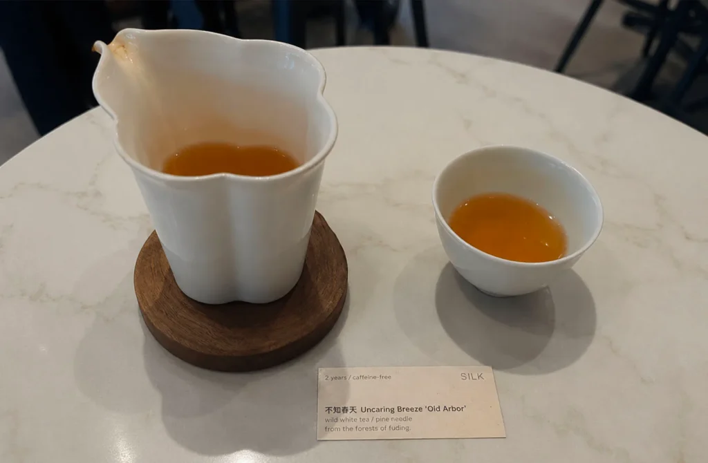 Pot and cup of premium white tea served at SILK Tea Bar.